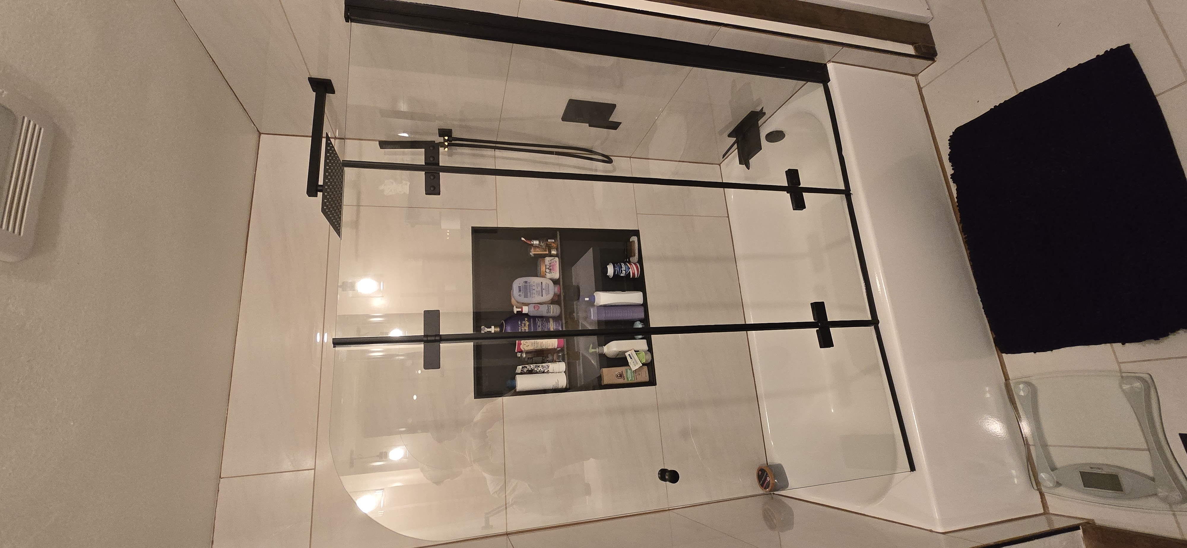 Finished bathroom remodel with marble-look tile and navy vanity