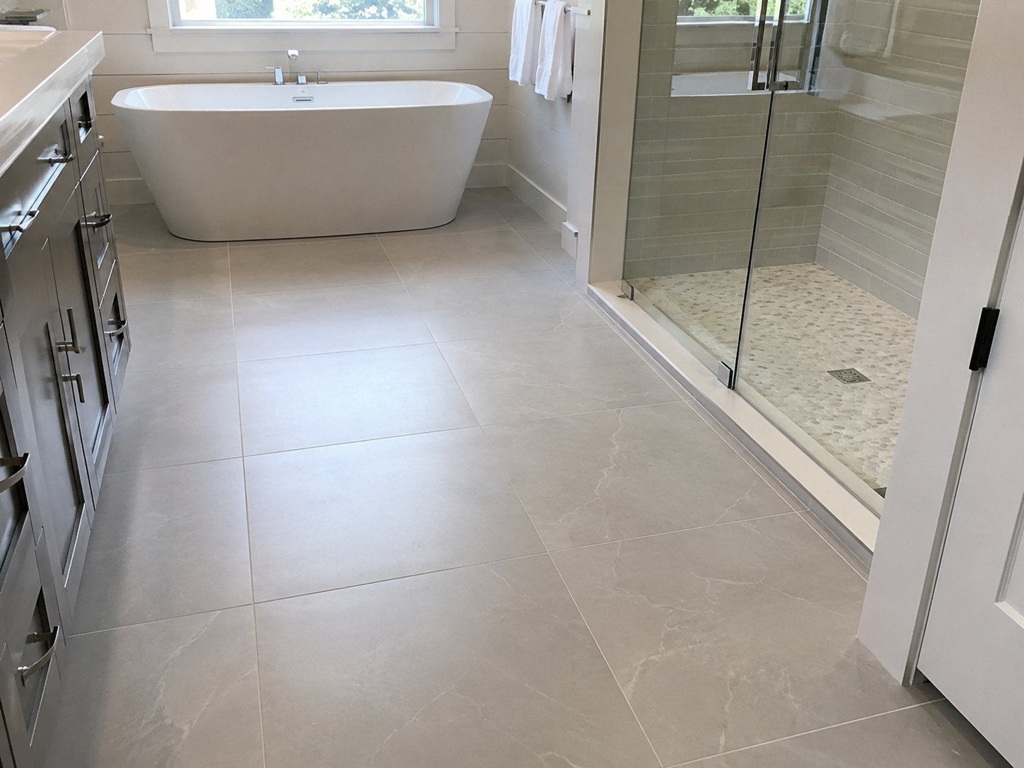 New tile bathroom floor and freestanding tub after remodel
