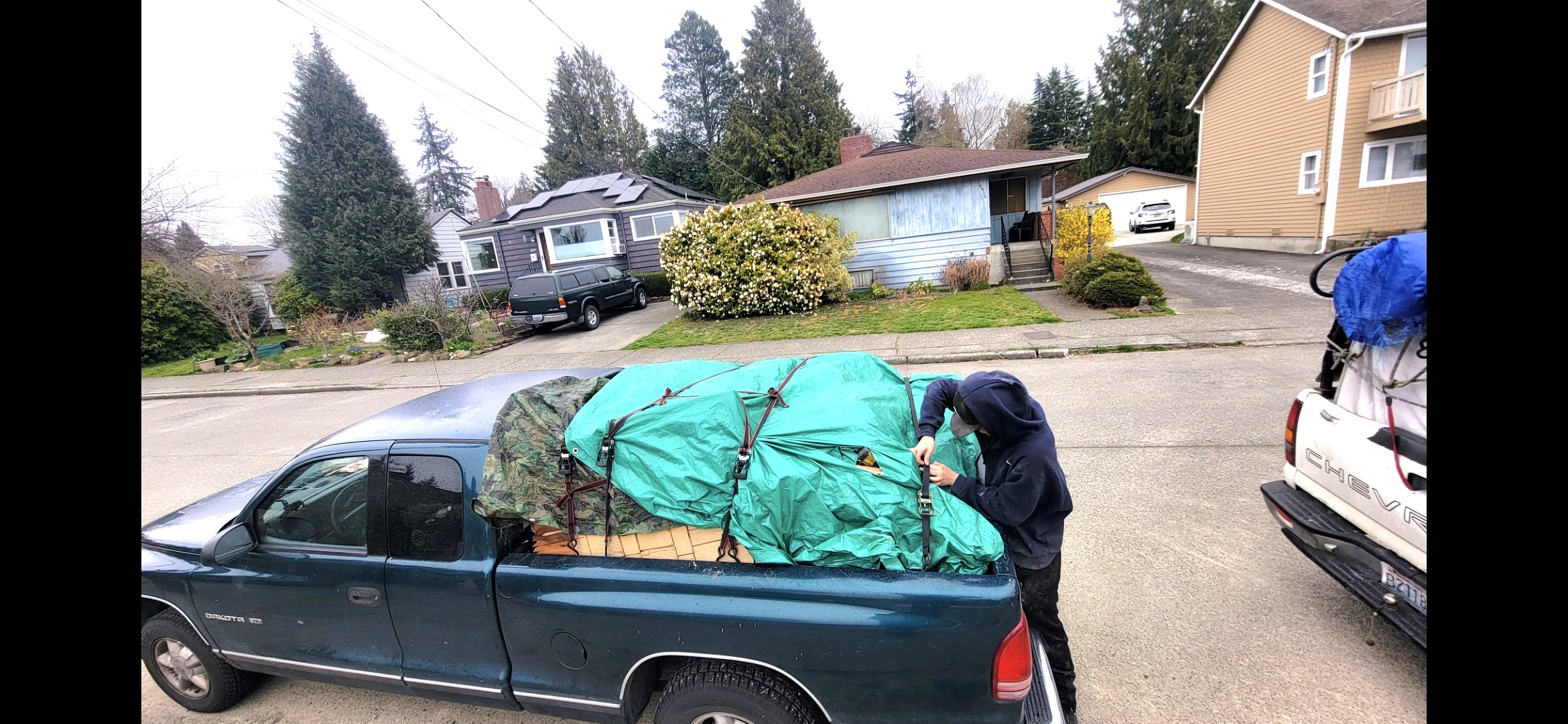 Crew member securing tarp on loaded truck