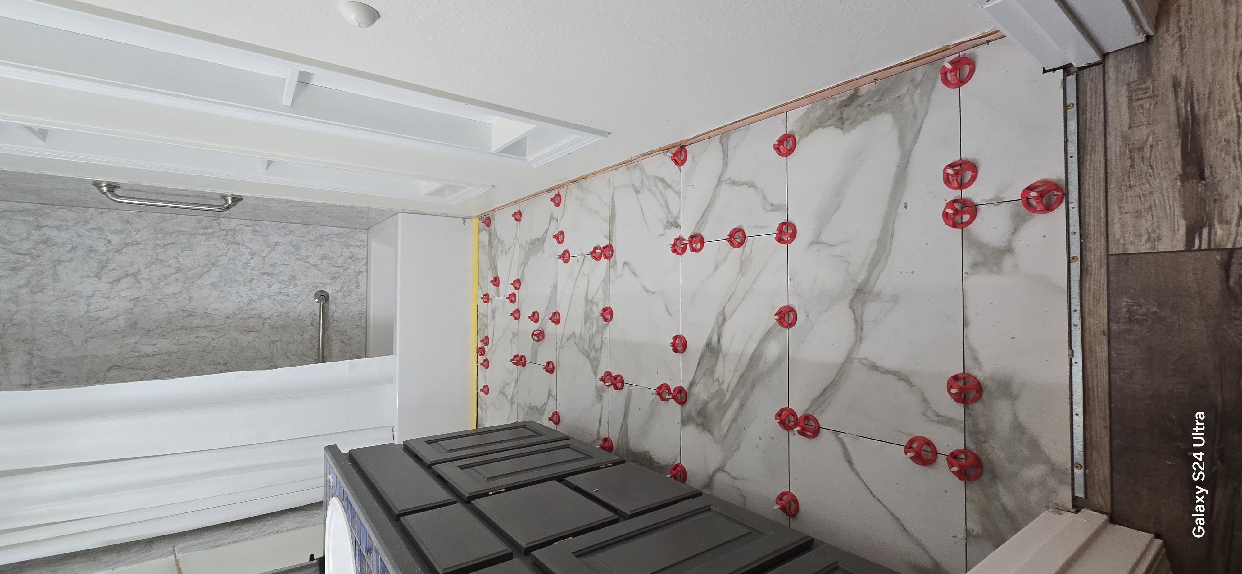 Tile installation with leveling clips on bathroom wall